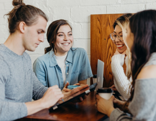 Four people smiling in a meeting